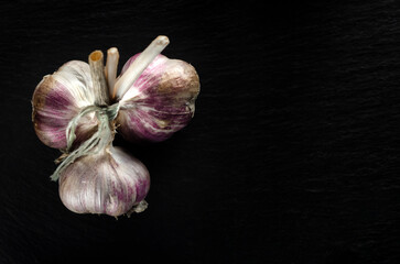 Garlic bulbs and garlic cloves on a black background. Close-up, flat lay, top view. Food background