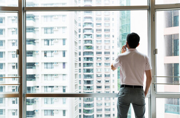 Man using phone in front of the window