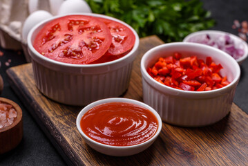 Ingredients for making shakshuka, dishes with fried eggs with tomato sauce, spices and herbs
