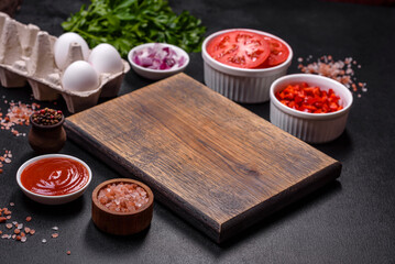 Ingredients for making shakshuka, dishes with fried eggs with tomato sauce, spices and herbs