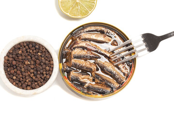 canned smoked sprats in oil with spices and lemon top view