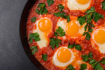 Shakshuka, a dish with fried eggs with tomato sauce, sweet pepper, garlic, onions, spices and herbs