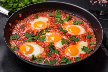 Shakshuka, a dish with fried eggs with tomato sauce, sweet pepper, garlic, onions, spices and herbs
