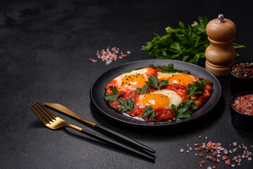 Shakshuka, a dish with fried eggs with tomato sauce, sweet pepper, garlic, onions, spices and herbs