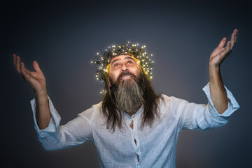man with crown of led lights and raised arms