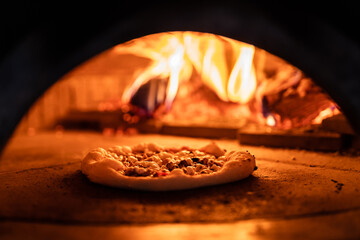 Pizza concept. Preparing traditional italian pizza. Long shovel for pizza, baking dough in a...