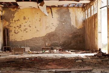 War-ravaged apartment with a lone chair in the center of the room. Sad destruction concepts and symbols