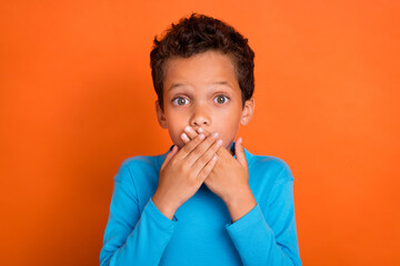 Photo of worried boy arm cover mouth dont speak stop talking shh wear stylish jumper isolated on orange color background