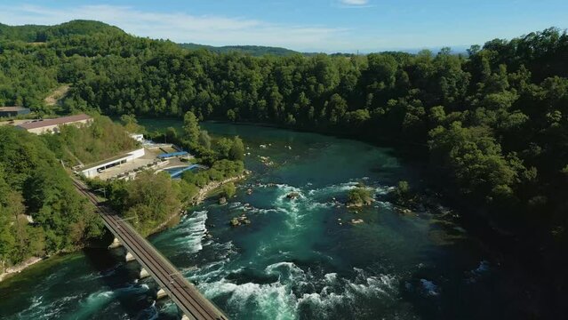 Fly over the Rhine waterfall bridge towards the forest during sunny day, Schaffhausen, Switzerland