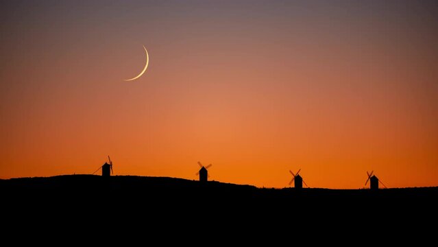 Timelapse of the crescent moon setting behind the iconic Consuegra windmills in Spain