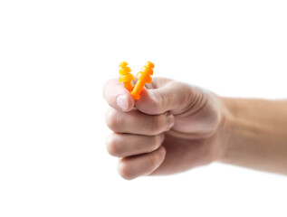 The hand holds bright earplugs on a white background
