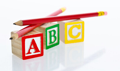 Pencils and ABC blocks on white background
