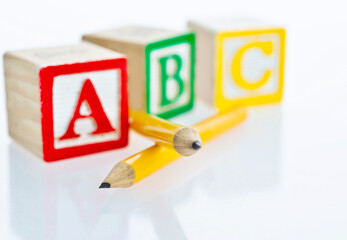 Pencils and ABC blocks on white background