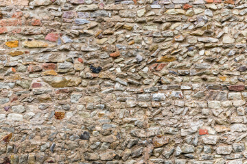 Wand oder Mauer aus Naturstein Ziegeln mit tiefen Fugen Hintergrund