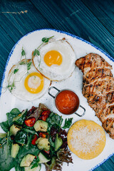fried eggs with meat and salad
