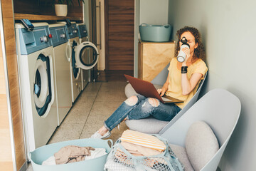 Woman with laptop waiting for laundry.