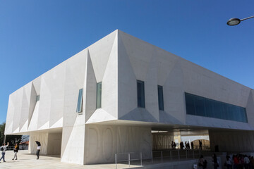 Gouveia, Portugal, march 17 2014; Side view of the modern Gouveia courthouse building over a blue spring sky with people under it