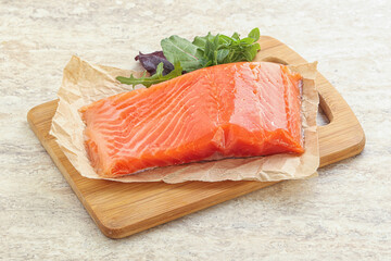 Raw salmon fillet over board