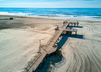 Crest beach in Wildwood New Jersey on the Atlantic ocean beach with wooden dock from above - obrazy, fototapety, plakaty