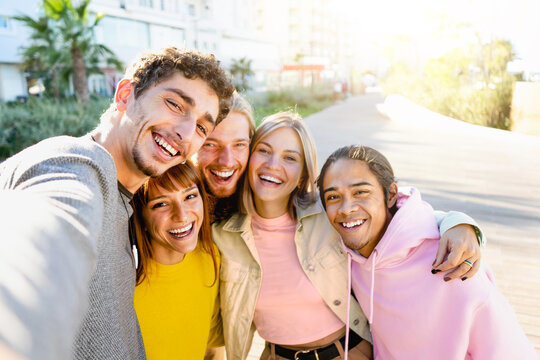 happy group of young  friends taking selfie  pic with smartphone outdoors-multiracial guys take a photo with cell phone- cheerful college student smiling at camera in the park-Friendship Concept