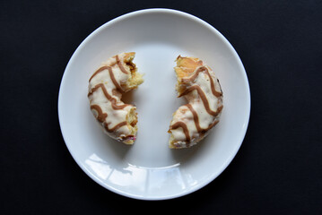 Delicious sweet donuts on a white plate. Donuts in glaze with filling close-up.