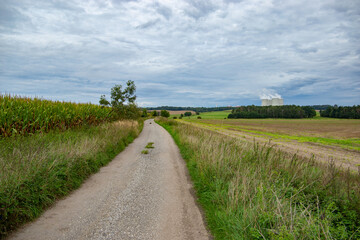 Road through green fields and mountains on a horizon. Early autumn.