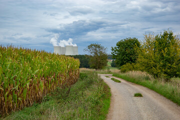 Fototapeta na wymiar Road through green fields and Temelin power station on a horizon. Early autumn.
