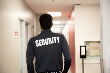 Fototapeta na wymiar A security guard is patrolling an office at night.