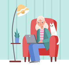 Elderly woman is working on laptop at home