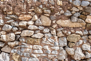 Rocky wall construction background texture. Old grey beige rough stonewall with cement. Copy space