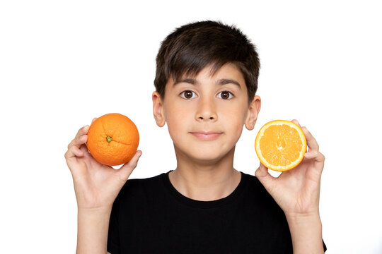 Photo of adorable young happy boy looking at camera.Isolated on the white background. Cute healthy boy holding an Orange.