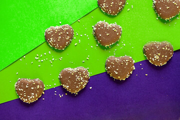 chocolate cookies hearts with nuts on colorful background. flat lay on colored paper. Chocolate chips
