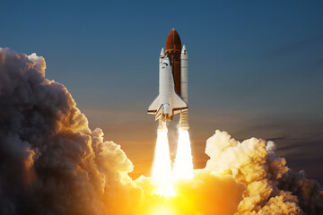 Spaceship lift off. Space shuttle with smoke and blast takes off into space on a background of sunset. Successful start of a space mission. Elements of this image furnished by NASA. - Powered by Adobe
