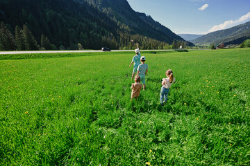 Fototapeta na wymiar Four children play in alpine meadow at Untertauern, Austria.