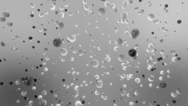 Monochrome particles flying slowly on a grey background. Motion. Small spheres in abstract space.