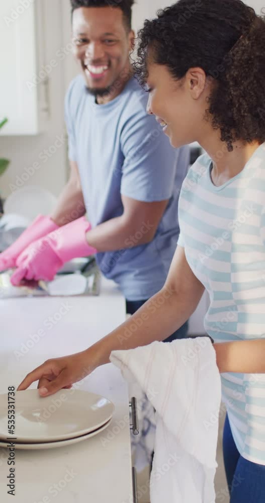 Canvas Prints Vertical video of happy african american couple washing dishes