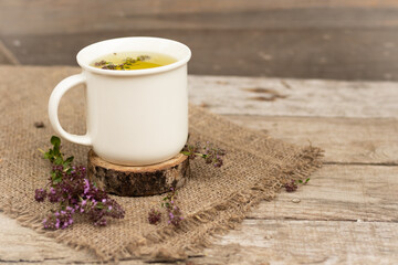 thyme tea is a therapeutic healthy drink Teapot and cup on a wooden background A bouquet of thyme on the table The concept of medicinal herbs.phytotherapy. Copy Space, mockup