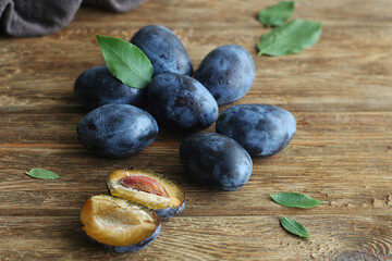 Ripe plum lies on a wooden table