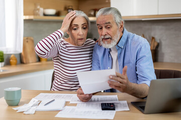 Budget Crisis. Shocked Elderly Spouses Checking Financial Documents At Home