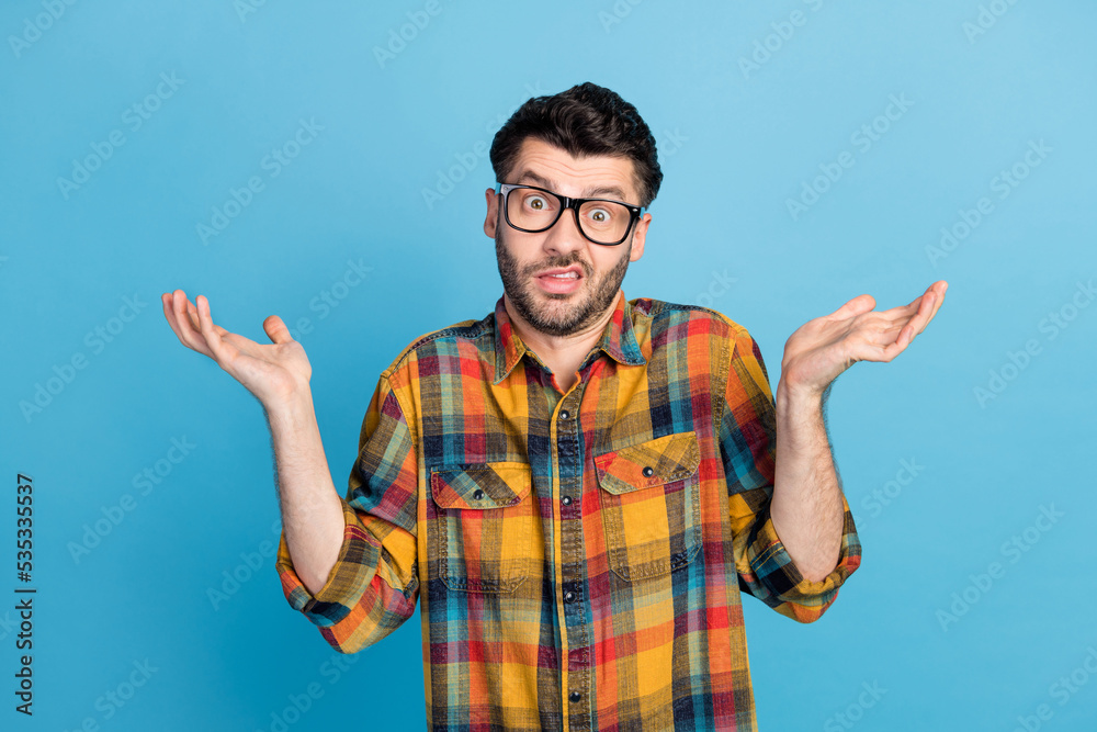 Canvas Prints Photo of handsome young confused guy in eyewear dressed plaid shirt question shrugging shoulders isolated on blue color background