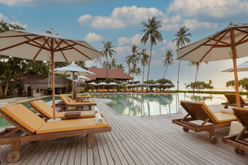 Swimming pool in a hotel pool resort with umbrellas beach and chairs