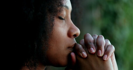 Pensive black woman praying. Thoughtful African person seeking help - obrazy, fototapety, plakaty