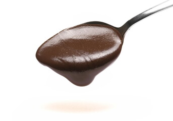 Sesame butter dripping with cocoa, tahini paste in spoon isolated on white  