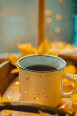 Cup Warm Coffee and Yellow Autumn Leaves by the Window. Fall Season and Home Cozy Concept. Vintage style.
