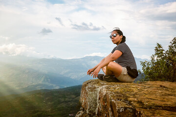 Naklejka premium Young woman doing tourism in old town of Colombia, woman looking at the landscapes of Barichara