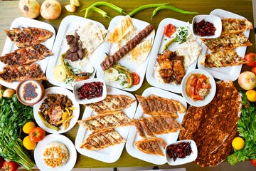 Delicious meat kebab with fresh vegetable salad served with variety of Turkish dishes and appetizers. Top view of assorted Turkish food and meze, tasty and healthy Mediterranean cuisine.
