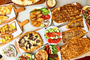 Delicious meat kebab with fresh vegetable salad served with variety of Turkish dishes and appetizers. Top view of assorted Turkish food and meze, tasty and healthy Mediterranean cuisine.