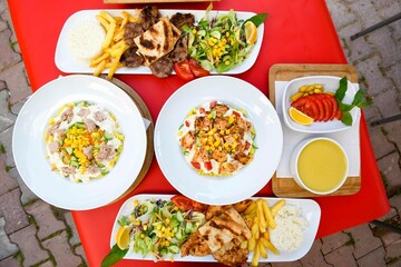 Delicious meat kebab with fresh vegetable salad served with variety of Turkish dishes and appetizers. Top view of assorted Turkish food and meze, tasty and healthy Mediterranean cuisine.