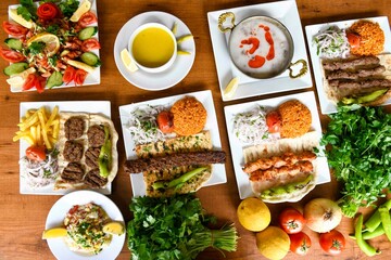 Delicious meat kebab with fresh vegetable salad served with variety of Turkish dishes and appetizers. Top view of assorted Turkish food and meze, tasty and healthy Mediterranean cuisine.