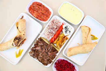 Delicious meat kebab with fresh vegetable salad served with variety of Turkish dishes and appetizers. Top view of assorted Turkish food and meze, tasty and healthy Mediterranean cuisine.